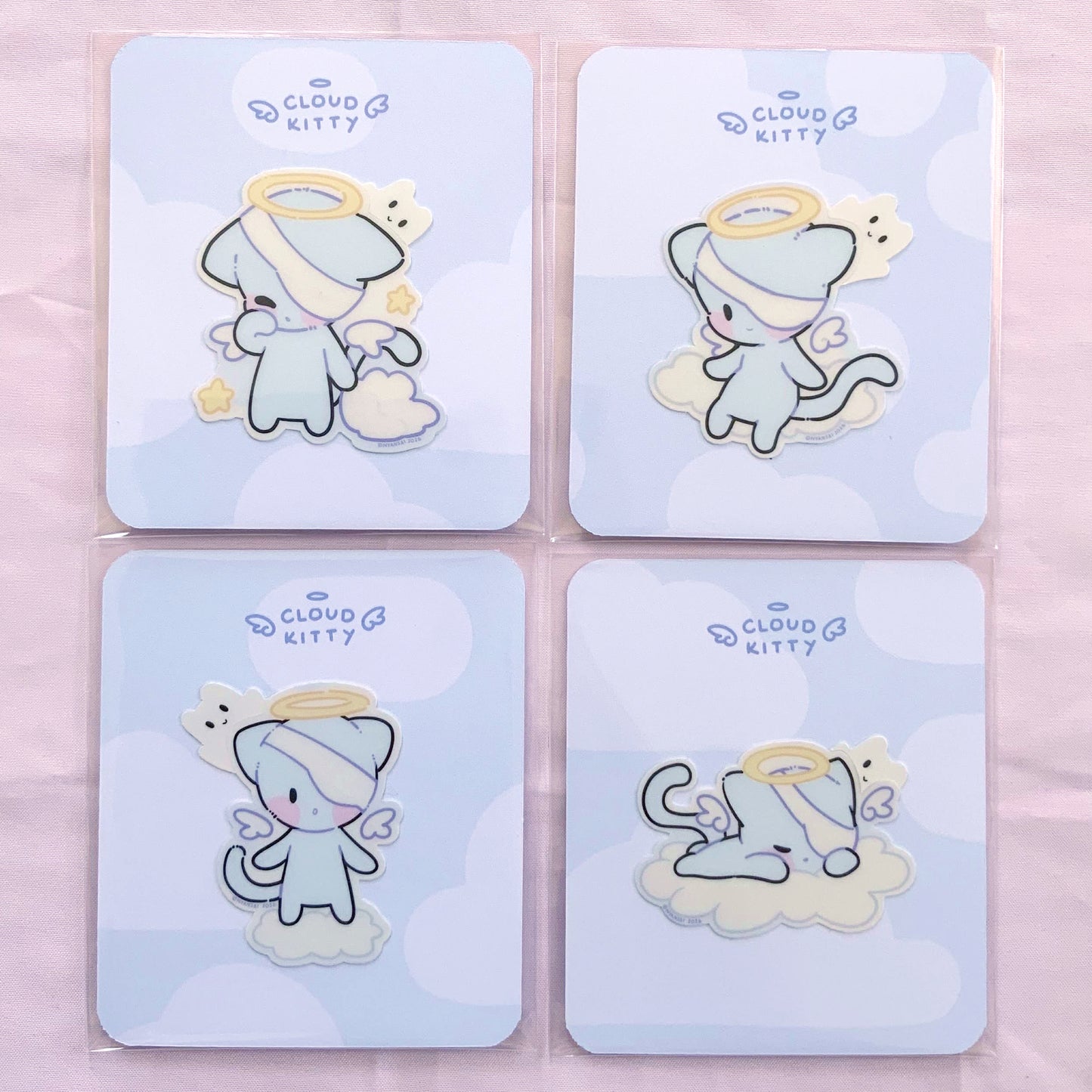 Four stickers of a cute kitty cloud-themed character, photographed on a pink background