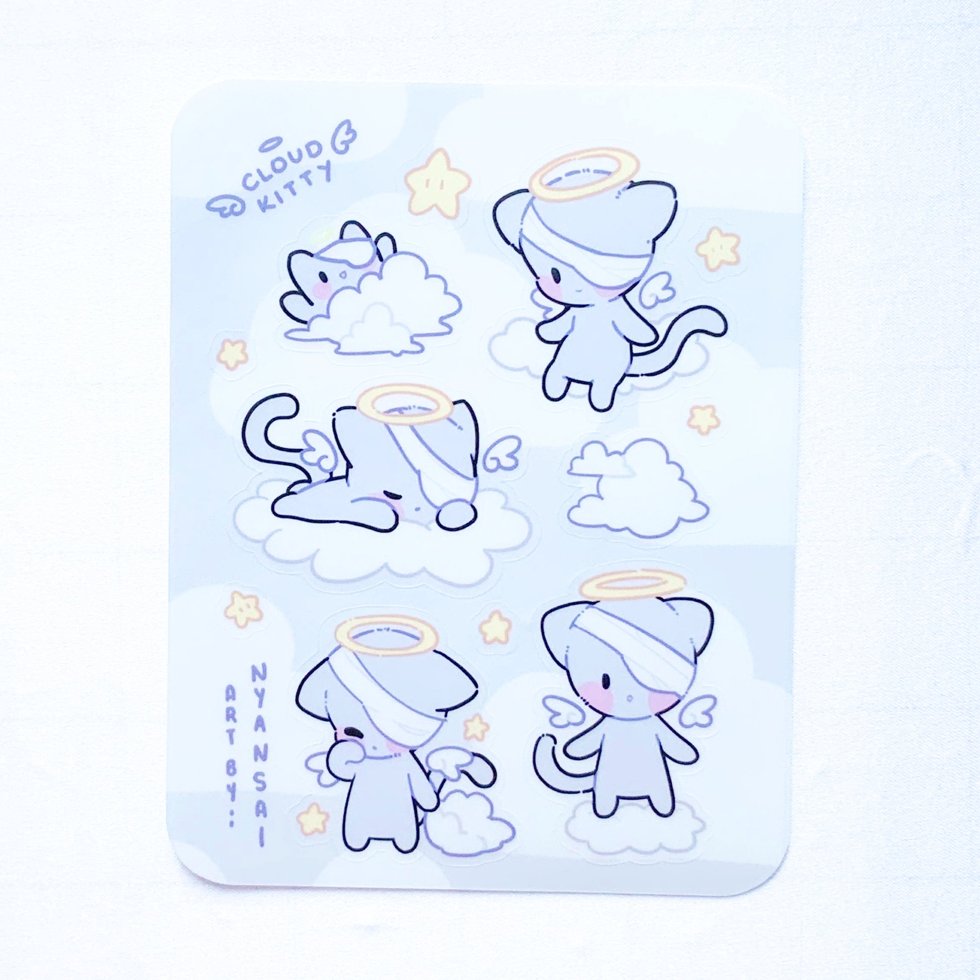 Sticker Sheet with cute cartoon cat illustrations with angel halos on a light blue background.