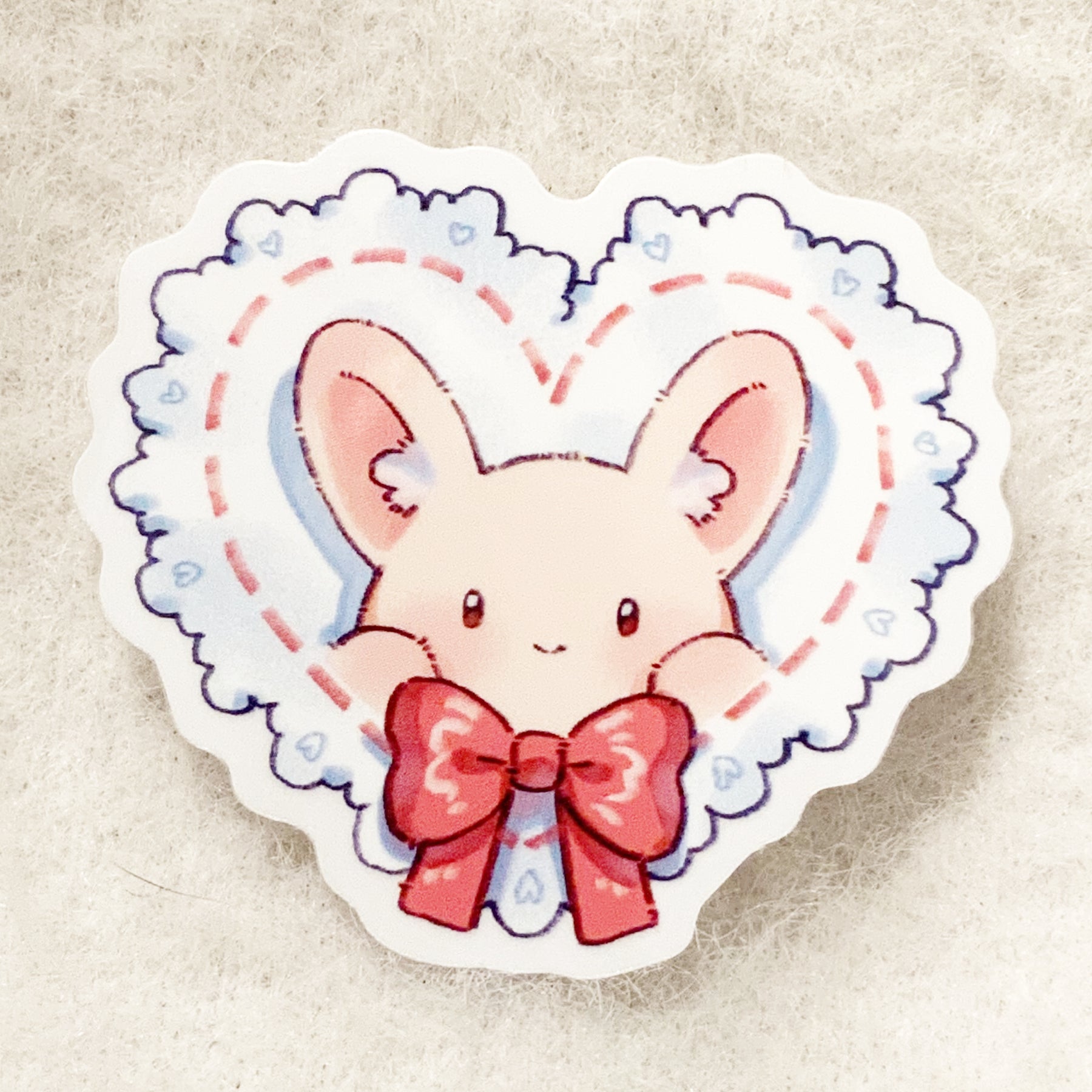 A sticker depicting a cute cartoon bunny with a heart and a bow tie.
