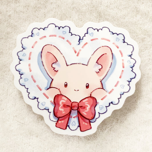 A sticker depicting a cute cartoon bunny with a heart and a bow tie.