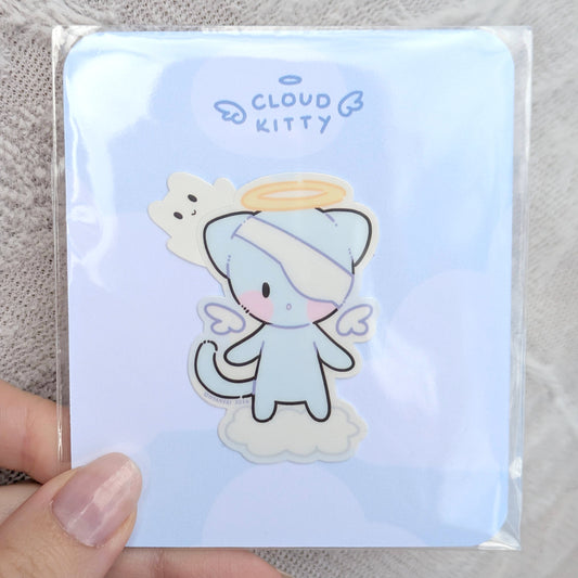 Cartoon cat character on a light blue card with 'Cloud Kitty' text, inside of a polybag, held by a hand.